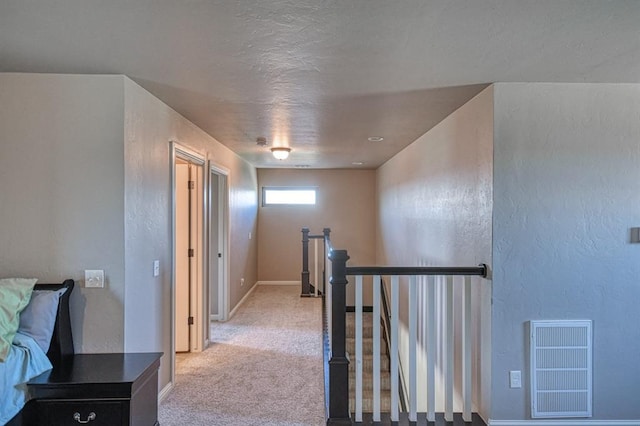 hall with light colored carpet