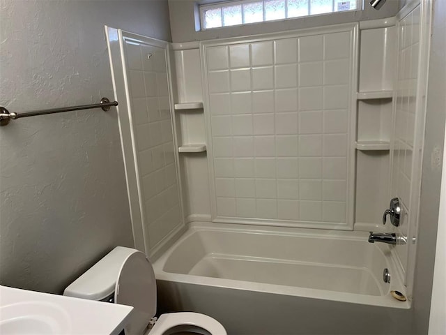 bathroom featuring shower / tub combination and toilet