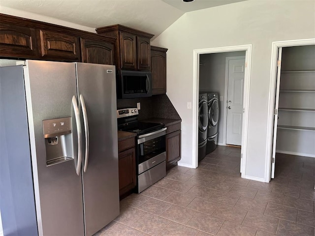 kitchen with tile patterned floors, dark brown cabinets, stainless steel appliances, vaulted ceiling, and washer and dryer