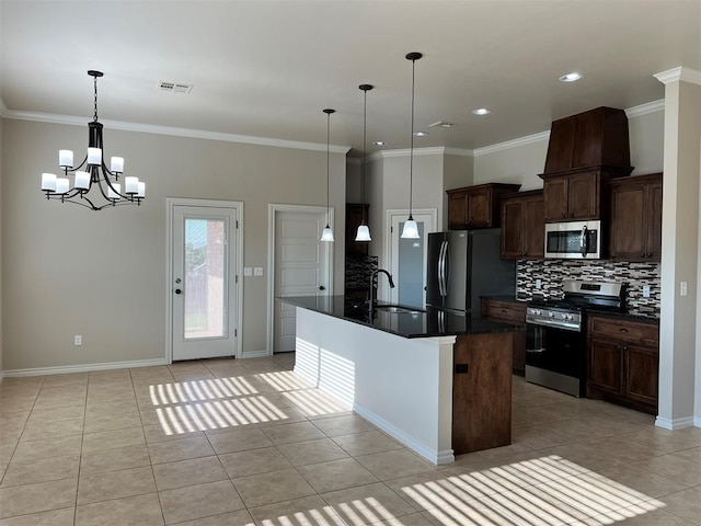 kitchen with pendant lighting, stainless steel appliances, a notable chandelier, and an island with sink