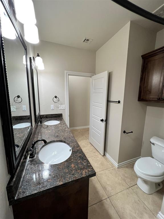 bathroom with tile patterned flooring, vanity, and toilet