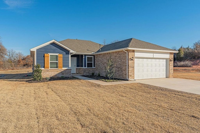 ranch-style home with a front yard, concrete driveway, brick siding, and an attached garage