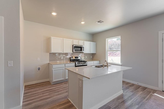 kitchen featuring sink, an island with sink, white cabinets, and stainless steel appliances