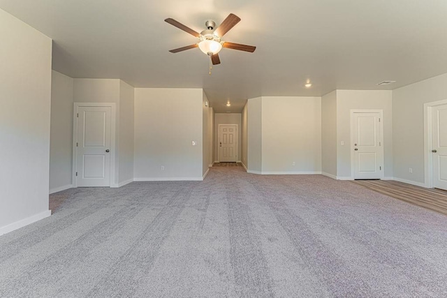 spare room with ceiling fan and light colored carpet