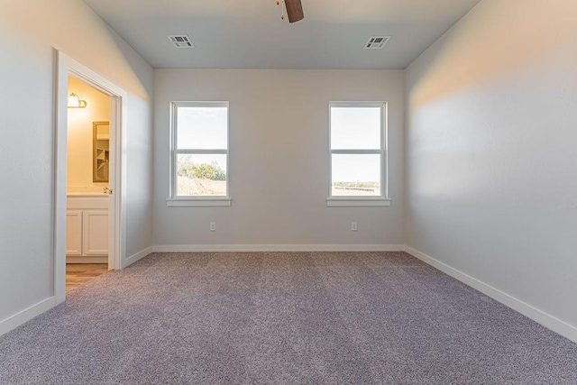 unfurnished room featuring ceiling fan, a wealth of natural light, and light carpet