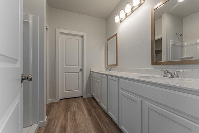 bathroom with hardwood / wood-style flooring, a shower, and vanity