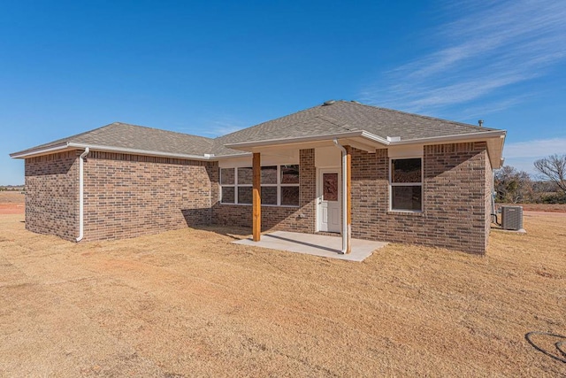 back of house featuring cooling unit, a patio, and a yard