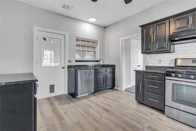 kitchen featuring stainless steel appliances, tasteful backsplash, light hardwood / wood-style floors, and sink