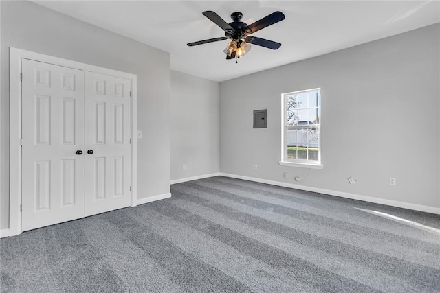 unfurnished bedroom featuring electric panel, ceiling fan, a closet, and carpet floors