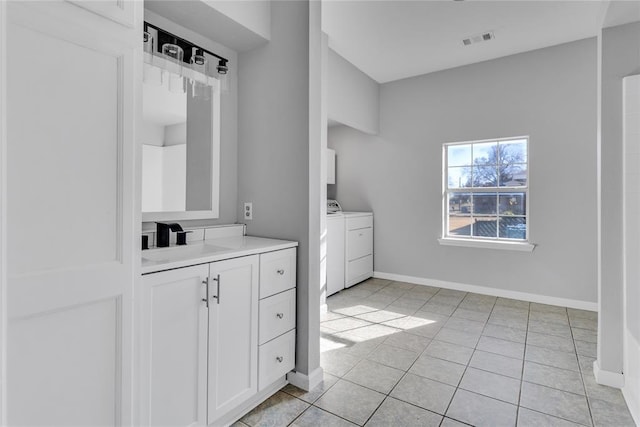 bathroom featuring washing machine and clothes dryer, tile patterned flooring, and vanity