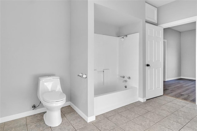 bathroom with wood-type flooring, toilet, and tiled shower / bath