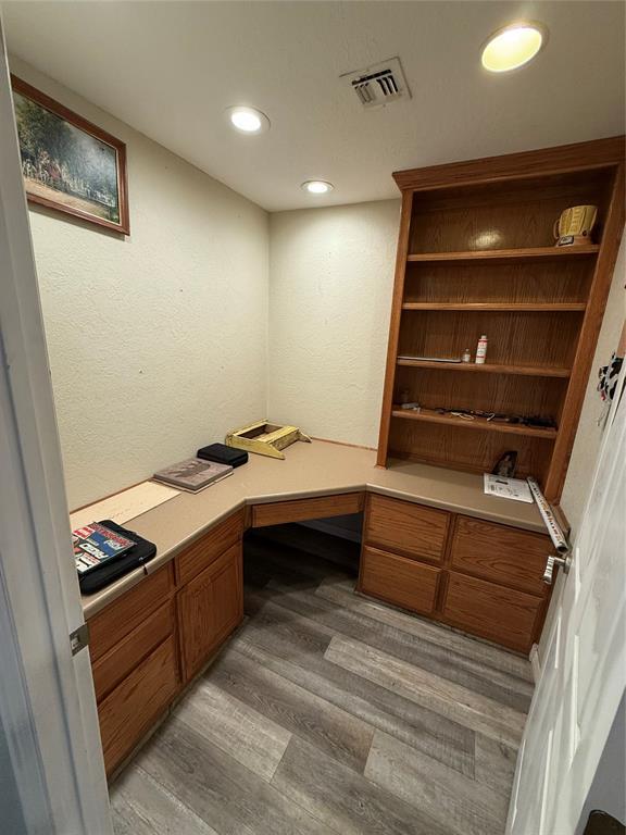 office space featuring light hardwood / wood-style floors and built in desk