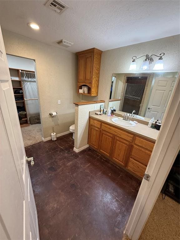 bathroom featuring vanity, toilet, and a textured ceiling