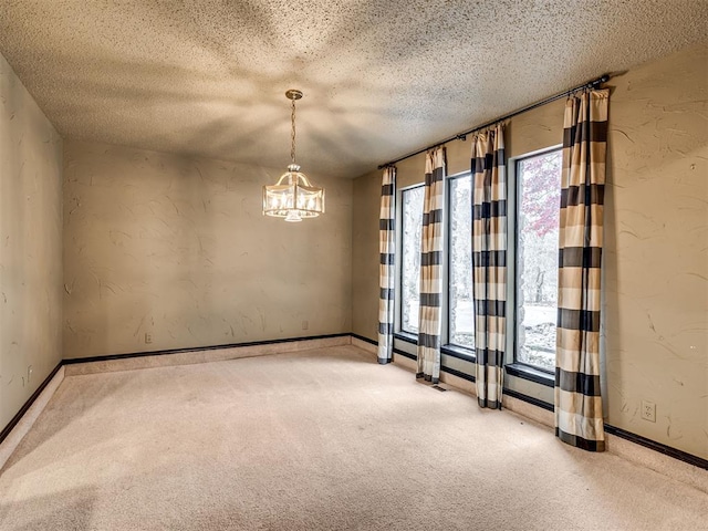 unfurnished room featuring light colored carpet, a healthy amount of sunlight, and a textured ceiling