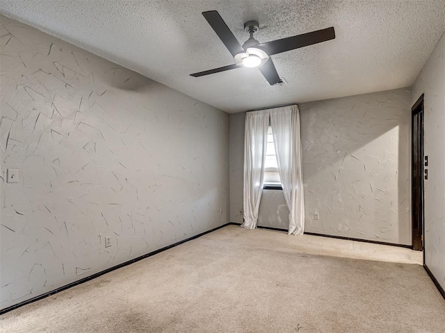 carpeted spare room featuring ceiling fan and a textured ceiling