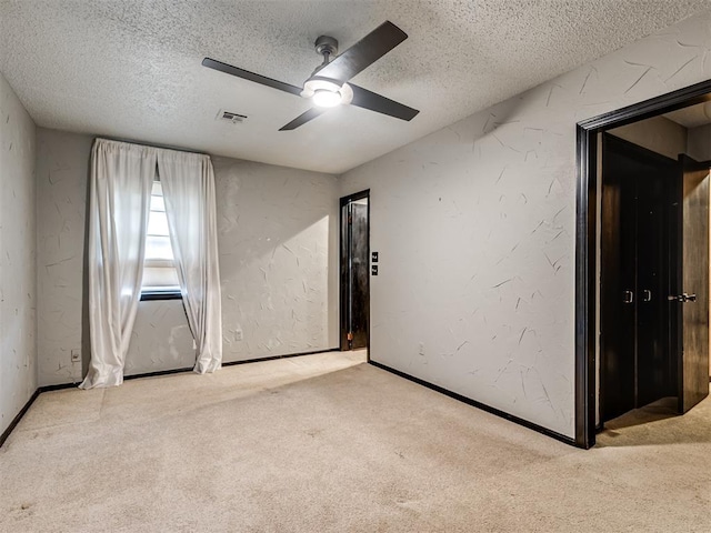 unfurnished room with ceiling fan, light colored carpet, and a textured ceiling