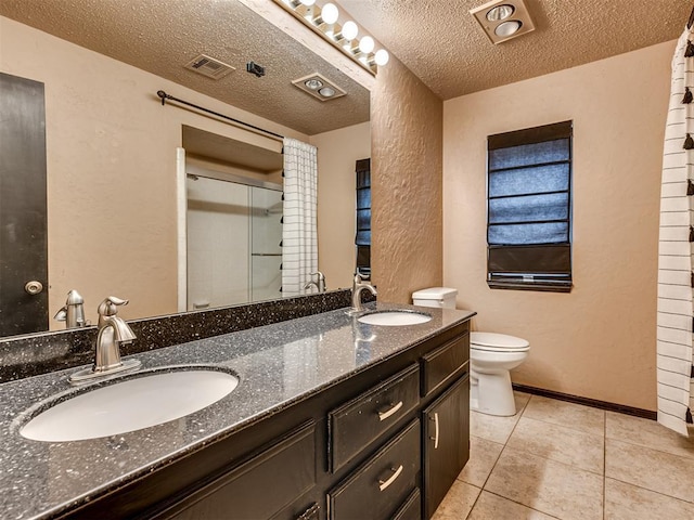 bathroom with vanity, a textured ceiling, tile patterned flooring, toilet, and a shower with shower door