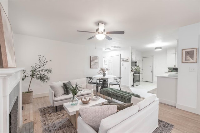 living room featuring light hardwood / wood-style floors and ceiling fan