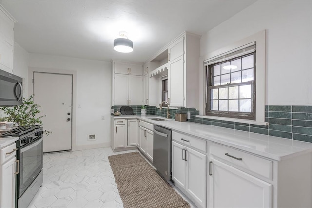 kitchen with stainless steel appliances, sink, decorative backsplash, and white cabinets