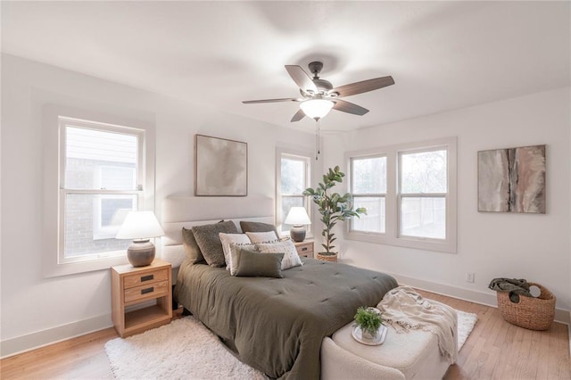 bedroom featuring multiple windows, light wood-type flooring, and ceiling fan