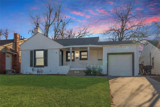 ranch-style house featuring a yard, a garage, and a porch