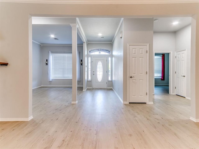 entrance foyer featuring ornamental molding and light wood-type flooring