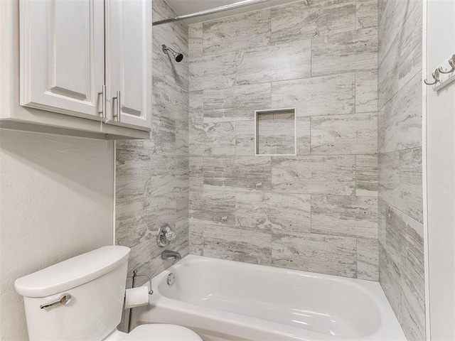 bathroom with tiled shower / bath combo and toilet