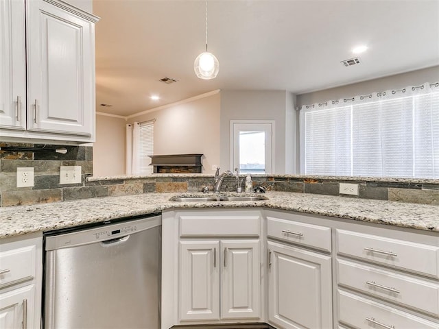 kitchen featuring pendant lighting, dishwasher, white cabinets, sink, and tasteful backsplash