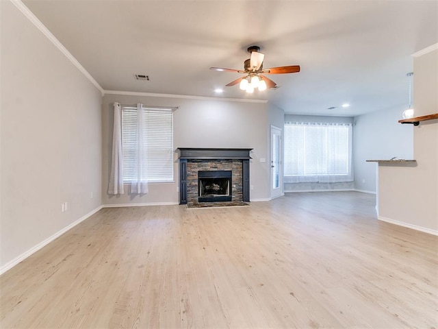 unfurnished living room featuring ceiling fan, a fireplace, ornamental molding, and light wood-type flooring