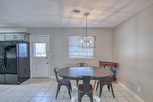 tiled dining area featuring a textured ceiling