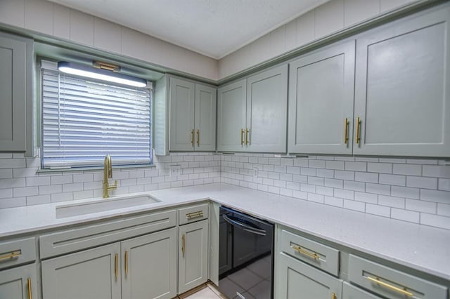 kitchen with tasteful backsplash, gray cabinetry, dishwasher, and sink