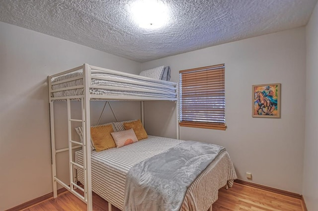 bedroom with hardwood / wood-style floors and a textured ceiling