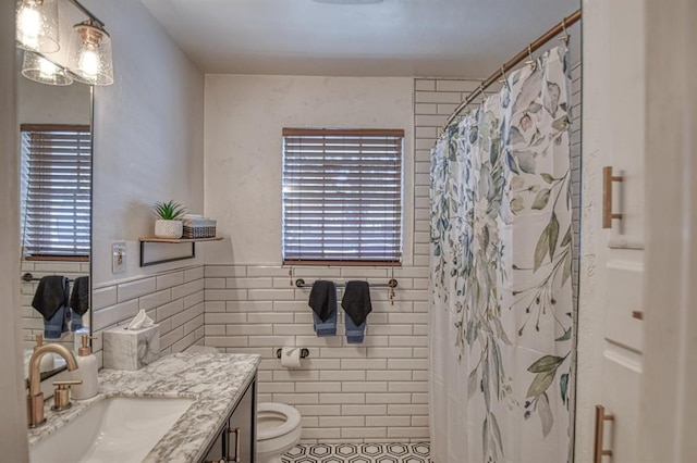 bathroom featuring vanity, plenty of natural light, and tile walls