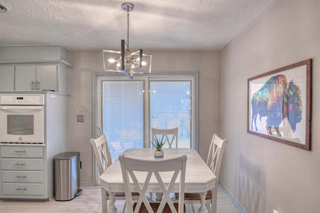 dining space with a chandelier and a textured ceiling