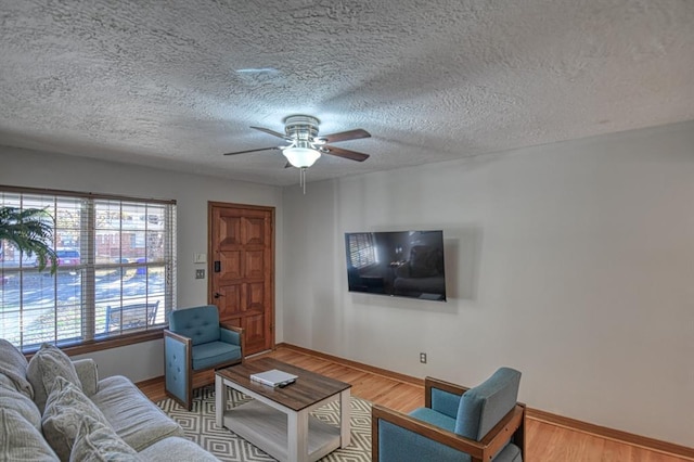 living room with ceiling fan, hardwood / wood-style floors, and a textured ceiling