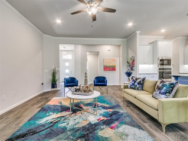 living room with crown molding, ceiling fan, and dark wood-type flooring