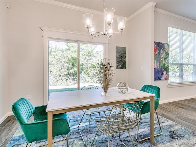 dining area featuring a notable chandelier, a healthy amount of sunlight, wood-type flooring, and ornamental molding