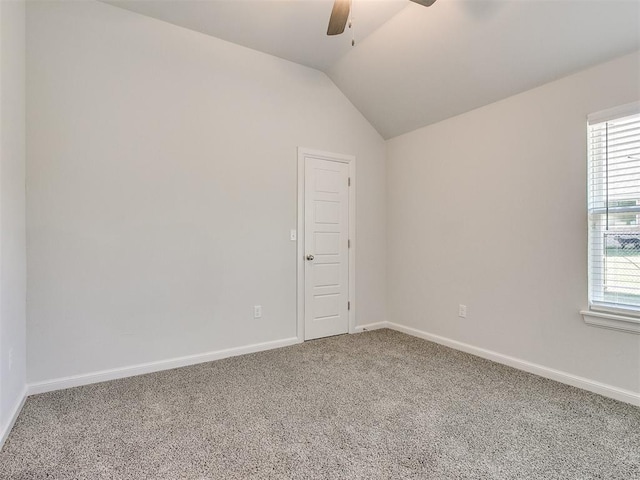 carpeted empty room featuring ceiling fan, a healthy amount of sunlight, and vaulted ceiling