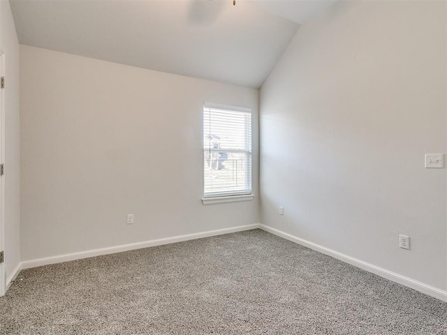 spare room featuring carpet floors and vaulted ceiling