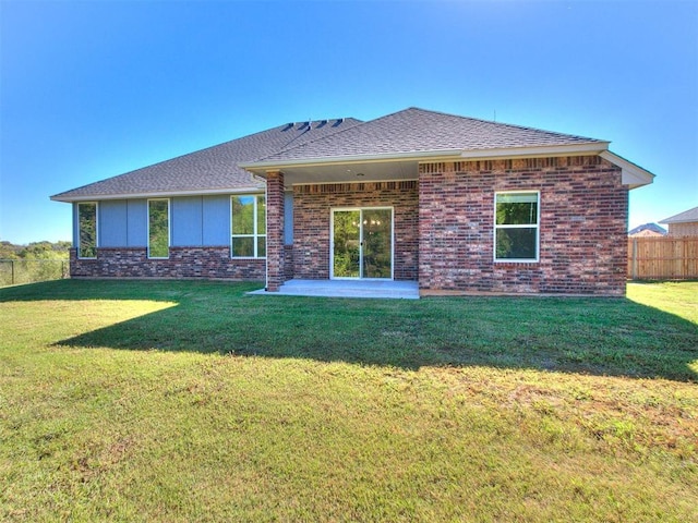 rear view of property with a lawn and a patio