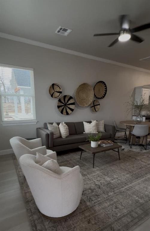 living room with ceiling fan, ornamental molding, and hardwood / wood-style floors