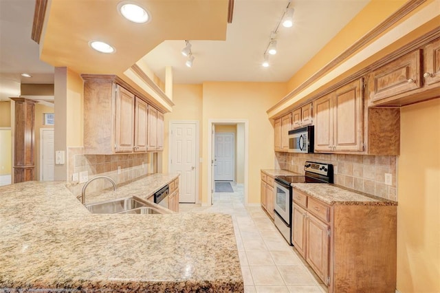 kitchen with decorative backsplash, appliances with stainless steel finishes, light brown cabinetry, sink, and light tile patterned floors