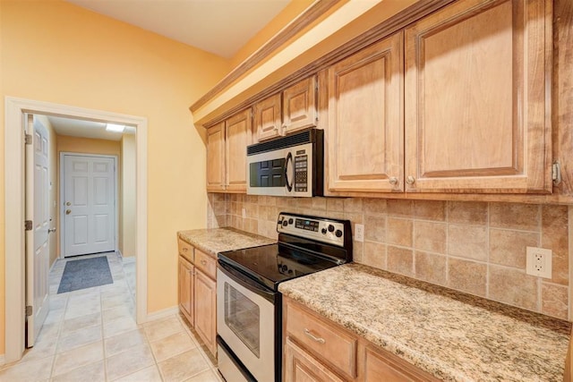 kitchen featuring light stone countertops, light tile patterned floors, backsplash, and stainless steel appliances