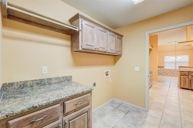 clothes washing area featuring cabinets, an inviting chandelier, hookup for an electric dryer, hookup for a washing machine, and light tile patterned floors