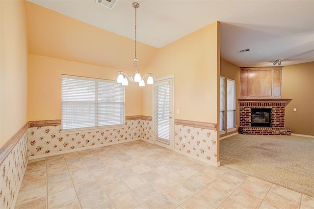 kitchen featuring a chandelier, a brick fireplace, hanging light fixtures, and a healthy amount of sunlight