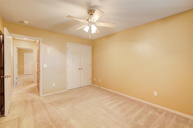 unfurnished bedroom with ceiling fan, light carpet, and a closet