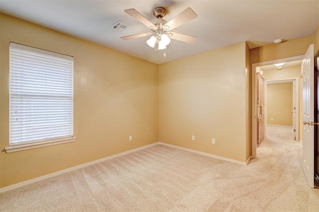 empty room featuring light colored carpet and ceiling fan