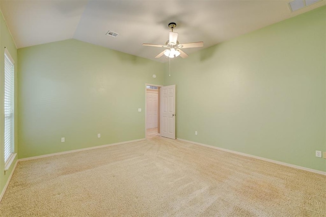 empty room with light carpet, plenty of natural light, ceiling fan, and lofted ceiling