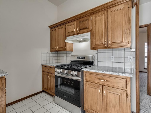 1036 SW 129th St, Moore, OK 73170 - kitchen featuring under cabinet range hood, stainless steel gas range, tasteful backsplash, light stone counters, and brown cabinets