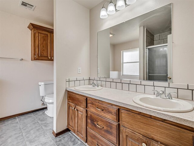 bathroom featuring vanity, tile patterned flooring, decorative backsplash, toilet, and walk in shower